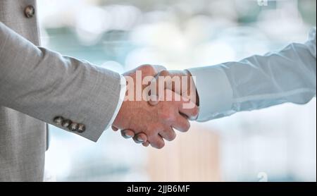 We have a deal. two unrecognizable males shaking hands in a office. Stock Photo