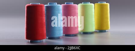 Fabric threads of different colors on gray background Stock Photo
