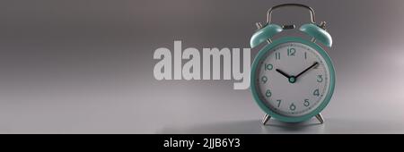 Turquoise alarm clock at ten o'clock on gray background Stock Photo