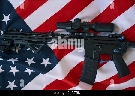 Gun with optical scope on background of American flag Stock Photo