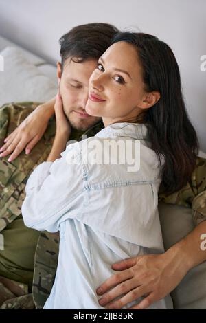 Woman wrapping arms around husband, portrait Stock Photo - Alamy
