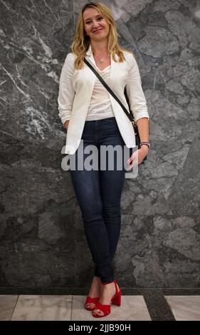 Beautiful blond mature woman standing against the wall Stock Photo