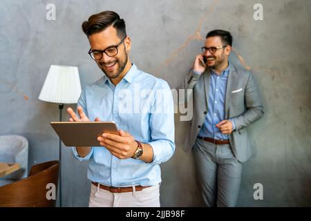 Diverse business people colleagues laughing having fun with digital gadgets in office. Stock Photo