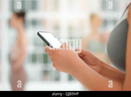 I want to download that app. an unrecognizable woman using her cellphone. Stock Photo