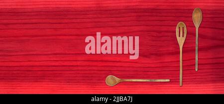 Topview of Set Cooking Wooden Spoons on Red Table Background Stock Photo