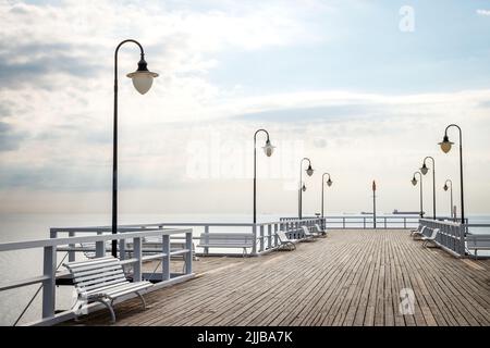 Pier with empty benches in Gdynia Orlowo, Poland. Travel destination at coastline of Baltic sea Stock Photo
