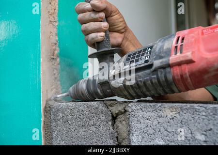 Technicians use a drill to drill holes in the masonry to strengthen the structure in the construction. Stock Photo