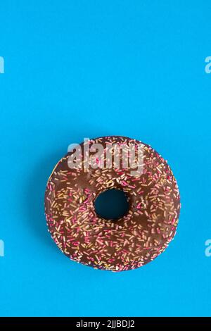 Close up of donut with sprinkle on blue modern background. Copy space Stock Photo