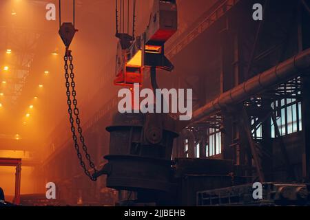 Metallurgy plant interior. Foundry worker on big mold for iron cast. Heavy industry. Steel Mill. Stock Photo