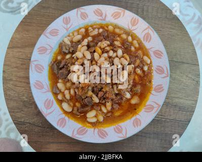 White beans stewed with smoked ribs, onions, carrots, garlic, red paprika, tomatoes and parsley. Stock Photo