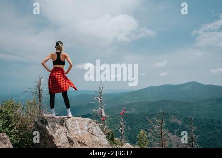 A girl on top of Falaza mountain looks at a beautiful mountain valley. Travel and tourism. Hiking Stock Photo