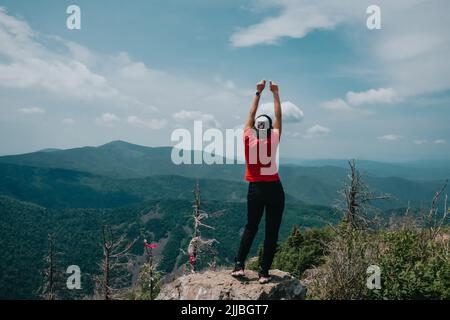 A girl on top of Falaza mountain looks at a beautiful mountain valley. Travel and tourism. Hiking Stock Photo