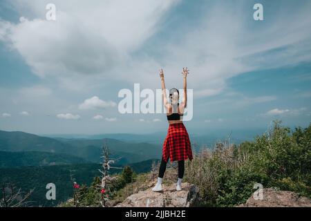 A girl on top of Falaza mountain looks at a beautiful mountain valley. Travel and tourism. Hiking Stock Photo