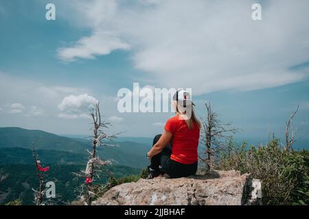 A girl on top of Falaza mountain looks at a beautiful mountain valley. Travel and tourism. Hiking Stock Photo