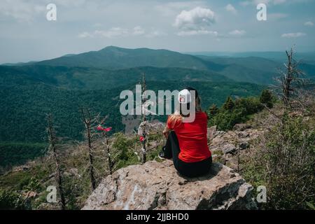 A girl on top of Falaza mountain looks at a beautiful mountain valley. Travel and tourism. Hiking Stock Photo