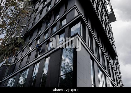 worker cleaning windows service on high rise building. industrial mountaineering Stock Photo