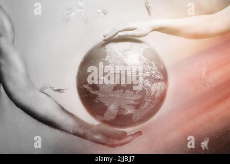 Women's and men's hands support the globe of planet Earth. Around the flying plastic debris. The concept of preserving the earth's environment.Red and Stock Photo