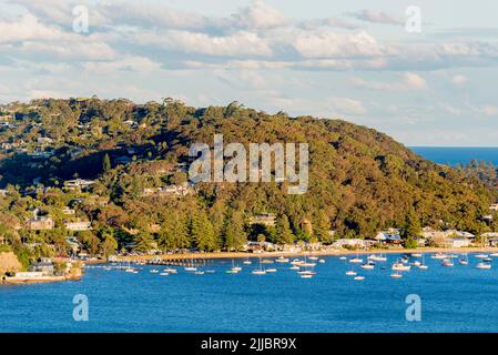 Boats moored on the Pittwater side of Palm Beach between Observation Point (L) and Sand Point (R) in Sydney Australia in the late afternoon winter sun