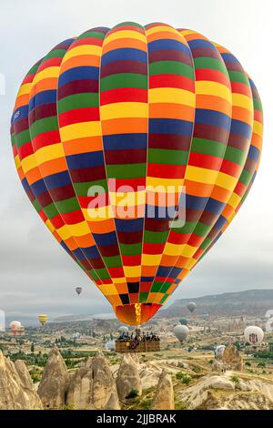 GOREME/TURKEY - June 29, 2022: colorful hot air balloon flies over the city of goreme. cappadocia. Stock Photo