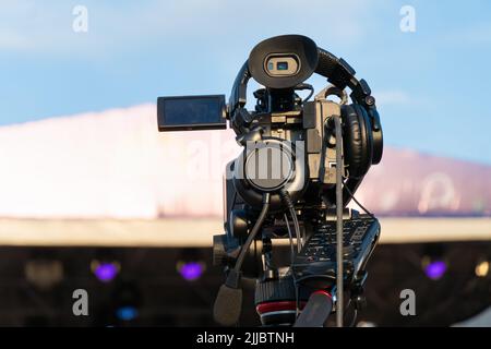 Professional digital video camera shoots video outdoors. on a sunny day, rear view Stock Photo