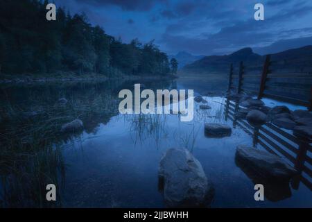 Dawn at Blea Tarn in Lake District, Cumbria,UK. Blue hour landscape scene with cloudy sky over beautiful mountain lake. Stock Photo