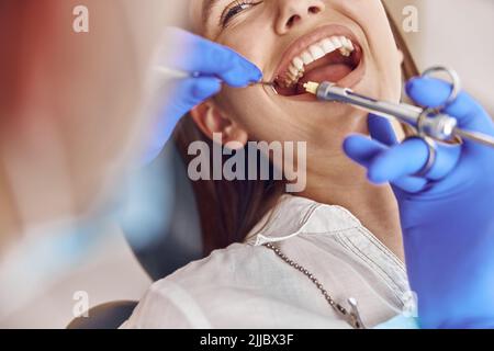 Professional male doctor is doing anestetic injection to happy female patient in stamotology cabinet Stock Photo