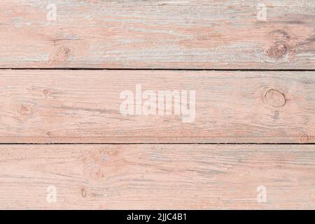 Peeling paint on a wooden floor. Soft pink abstract background of horizontal boards, grunge cracked painted surface, pattern texture. Weathered old wo Stock Photo