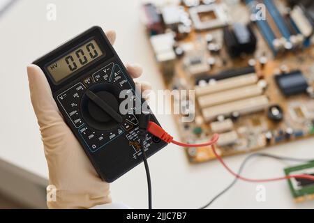 Close up of female engineer holding multimeter tool in laboratory, copy space Stock Photo
