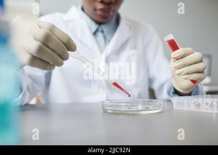 Close up of female technician preparing test sample while working in medical science lab, copy space Stock Photo
