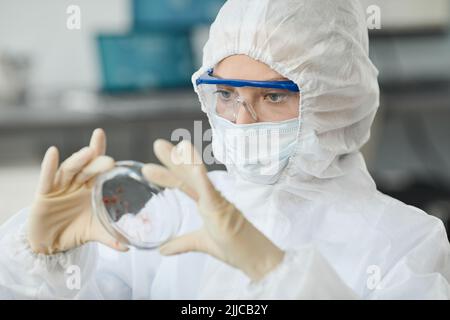 Portrait of woman wearing full protective gear while analyzing blood samples in medical laboratory Stock Photo