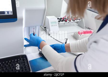 Technician centrifuging the blood of a sample in the laboratory Stock Photo