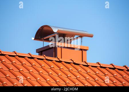 Chimney with standing seam cladding and aluminium sheet on a newly tiled roof Stock Photo