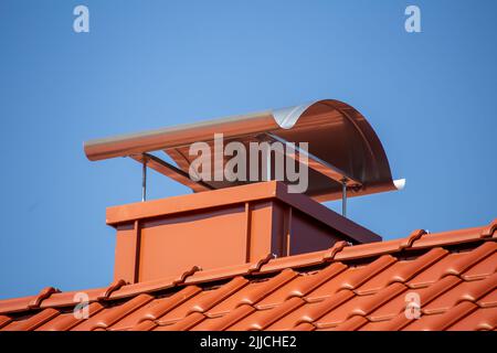 Chimney with standing seam cladding and aluminium sheet on a newly tiled roof Stock Photo