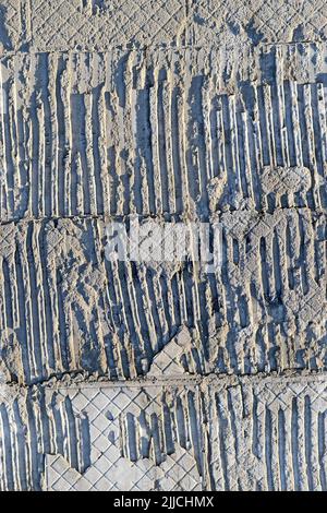 abstract uneven embossed textured concrete wall, stone material texture closeup diversity Stock Photo