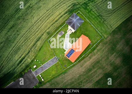 Vertical aerial view of an observation tower and a house with a few solar panels on its roof Stock Photo