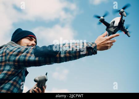 Man pilot Launches quadcopter FPV drone from hand to sky flight Stock Photo
