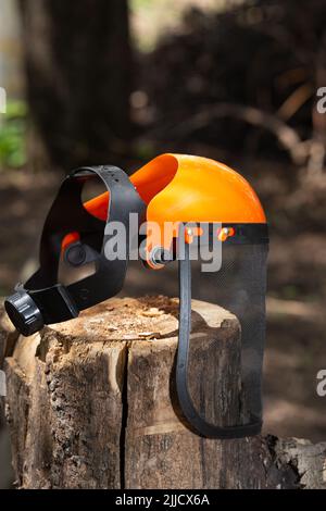 Safety Mesh visor face shield Industrial Protective Face mask lies on a stump Stock Photo