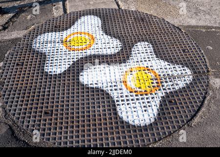 Fried egg graffiti on a manhole cover Stock Photo