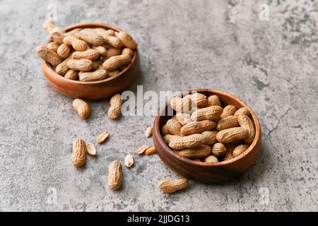 Image of bunch of peanuts in a bowl on a concrete surface Stock Photo