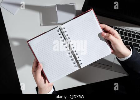 Woman Holding Notebook With New Ideas Over Desk With Notes And Lap Top. Stock Photo