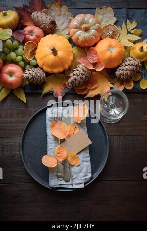 Autumn table place setting with drying leaves and pumpkins. Happy Thanksgiving Day. Vertical. Top view. Stock Photo