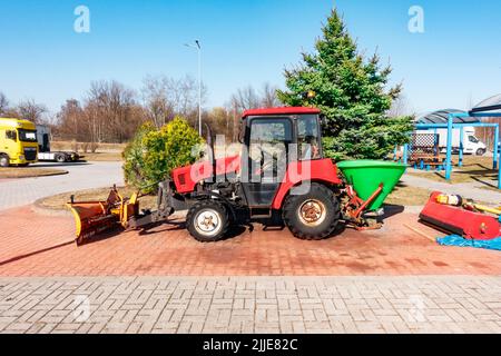 Old Belarus tractor for road works and sanding of the road. Tractor for carrying out road works and repairing the road surface in the parking lot. Mod Stock Photo