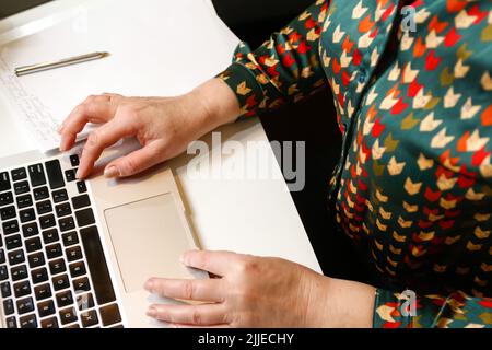 Defocus female hand typing laptop. Unrecognizable elegant woman working on computer at office. Start or finish of a work day. Workspace. Top view. Tim Stock Photo