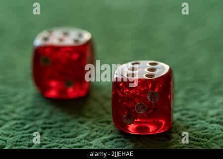 Close up photo of red and white dices on green background. Gambling and luck concept. Stock Photo