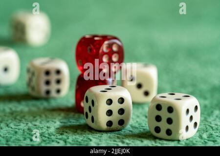 Close up photo of red and white dices on green background. Gambling and luck concept. Stock Photo
