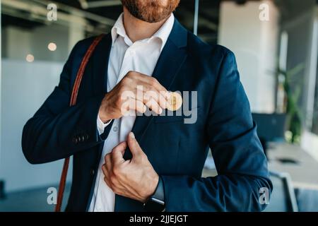 Future money and life with bitcoin concept. Investor man putting bitcoin to suit pocket, walking in office interior Stock Photo