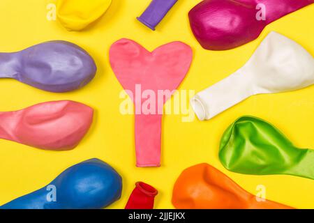 Colored deflated balloons on a yellow background Stock Photo