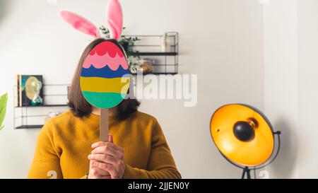 A long haired man keeping a colourful egg in his hands. High quality photo Stock Photo