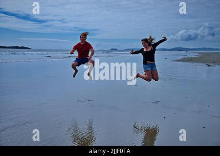 Mature couple jumping on the beach and having fun Stock Photo
