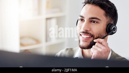Im sure I can find a solution for you. a handsome young male call center agent working in his office. Stock Photo